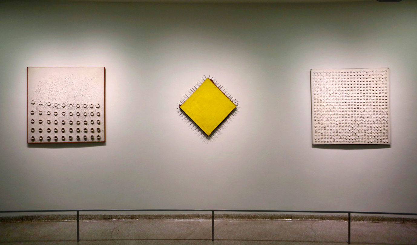 Van links naar rechts: “Dissolution of Formation” (1958), “The Yellow Picture” (1957–58) and “Cork Picture II” (1960) door Günther Uecker