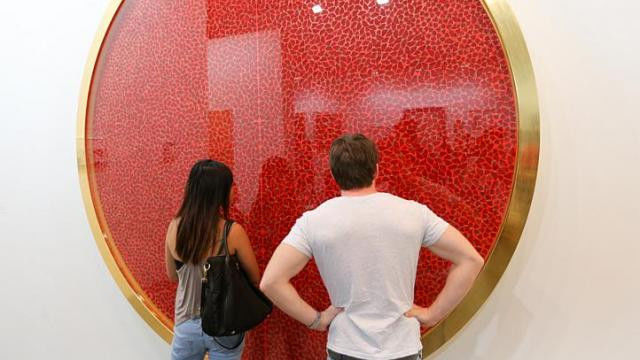 Kunstwerk van Damien Hirst op een beurs met 'rode stippen'; niet alle kunstwerken met en rode stip zijn al verkocht 